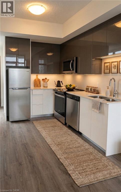 A modern kitchen with a refrigerator, sink, and cabinets.