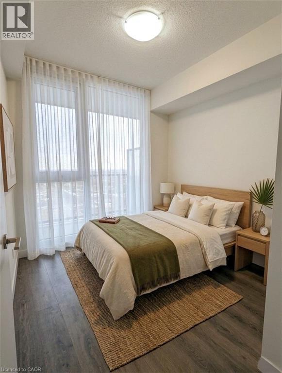A bedroom with a bed, nightstand, and window with curtains.
