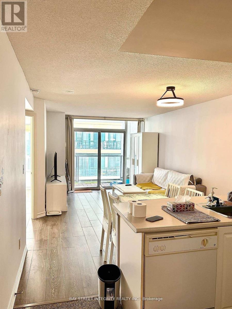 A kitchen with a white fridge, a white dishwasher, and a white chair.