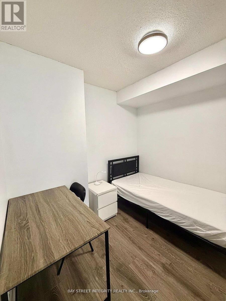 A bedroom with a bed, desk, and chair.