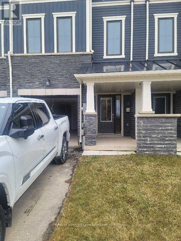A white truck is parked in front of a house.