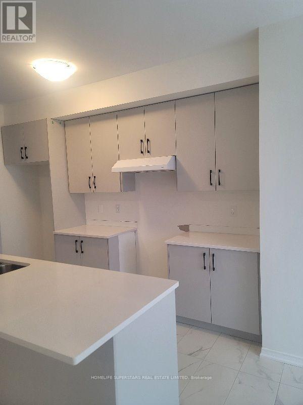 A kitchen with white cabinets and a counter top.