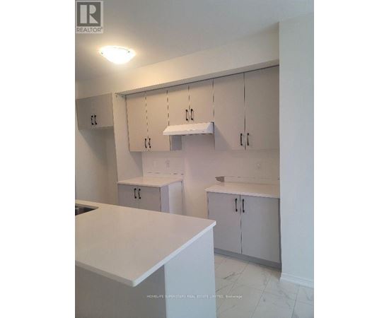 A kitchen with white cabinets and a counter top.