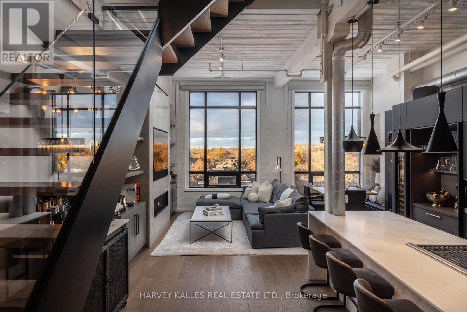 A modern living room with a staircase and a view of the outdoors.