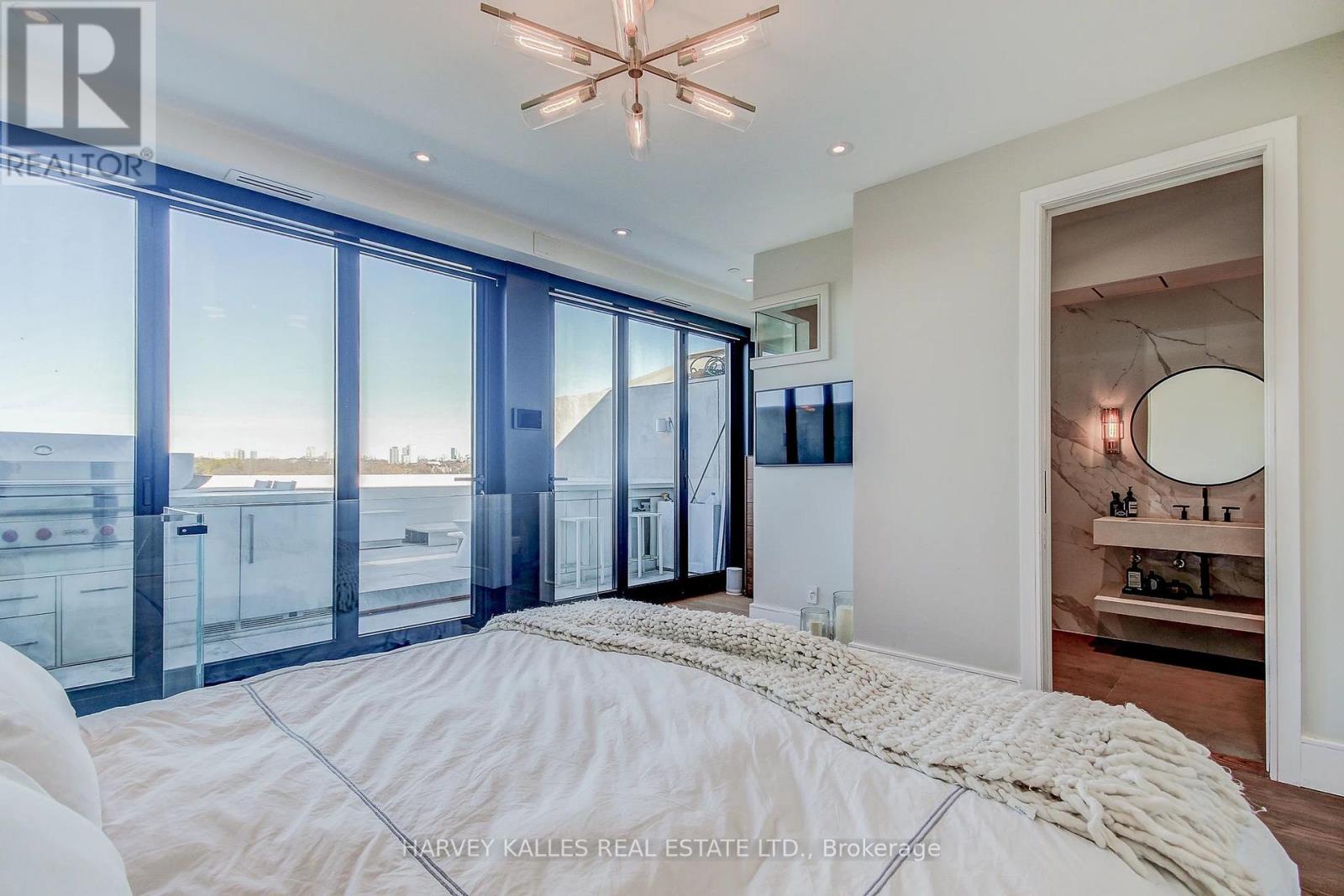 A bedroom with a large bed and a view of the ocean through the windows.