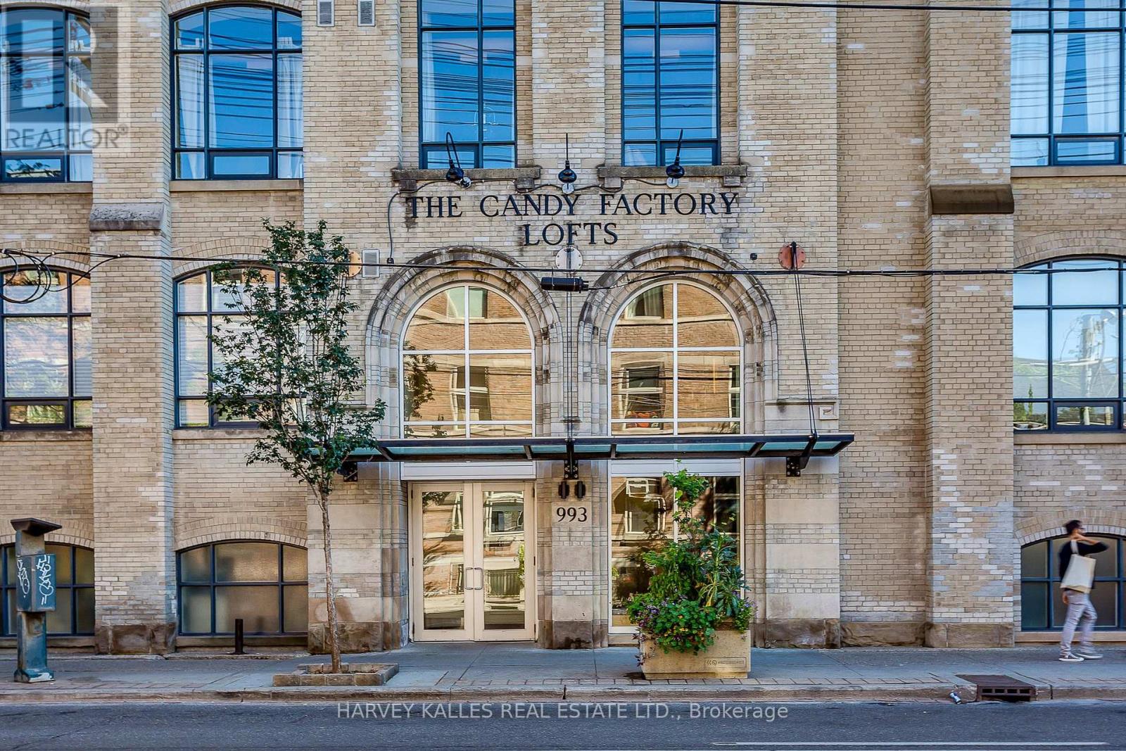 A building with a sign that says "The Candy Factory Lofts" on it.