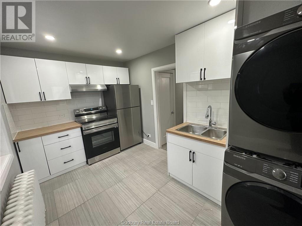 A kitchen with white cabinets and a black oven.