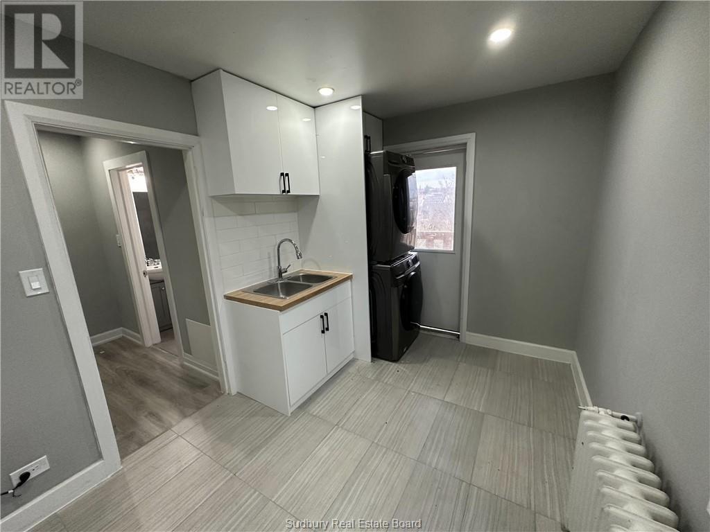 A small kitchen with a sink and a refrigerator.