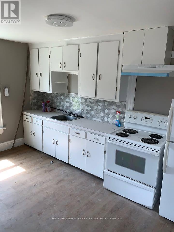 A kitchen with white appliances and cabinets.