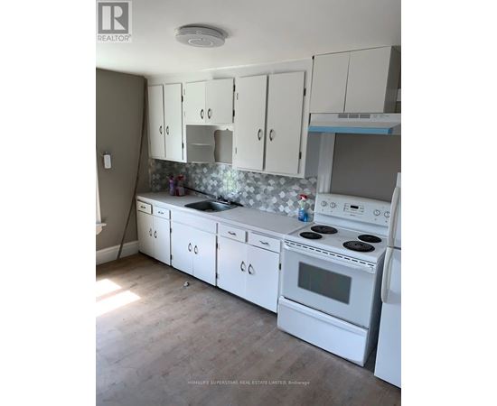 A kitchen with white appliances and cabinets.