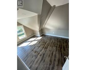 A room with a wooden floor and a window letting in sunlight.