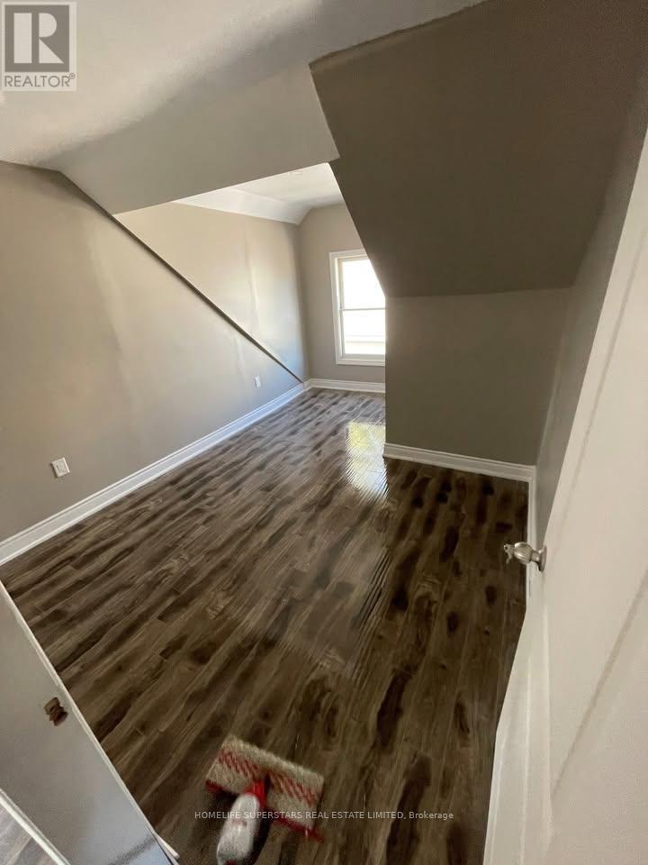 A room with wooden flooring and a window.