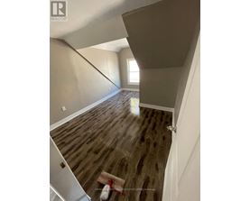 A room with wooden flooring and a window.