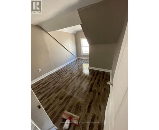 A room with wooden flooring and a window.
