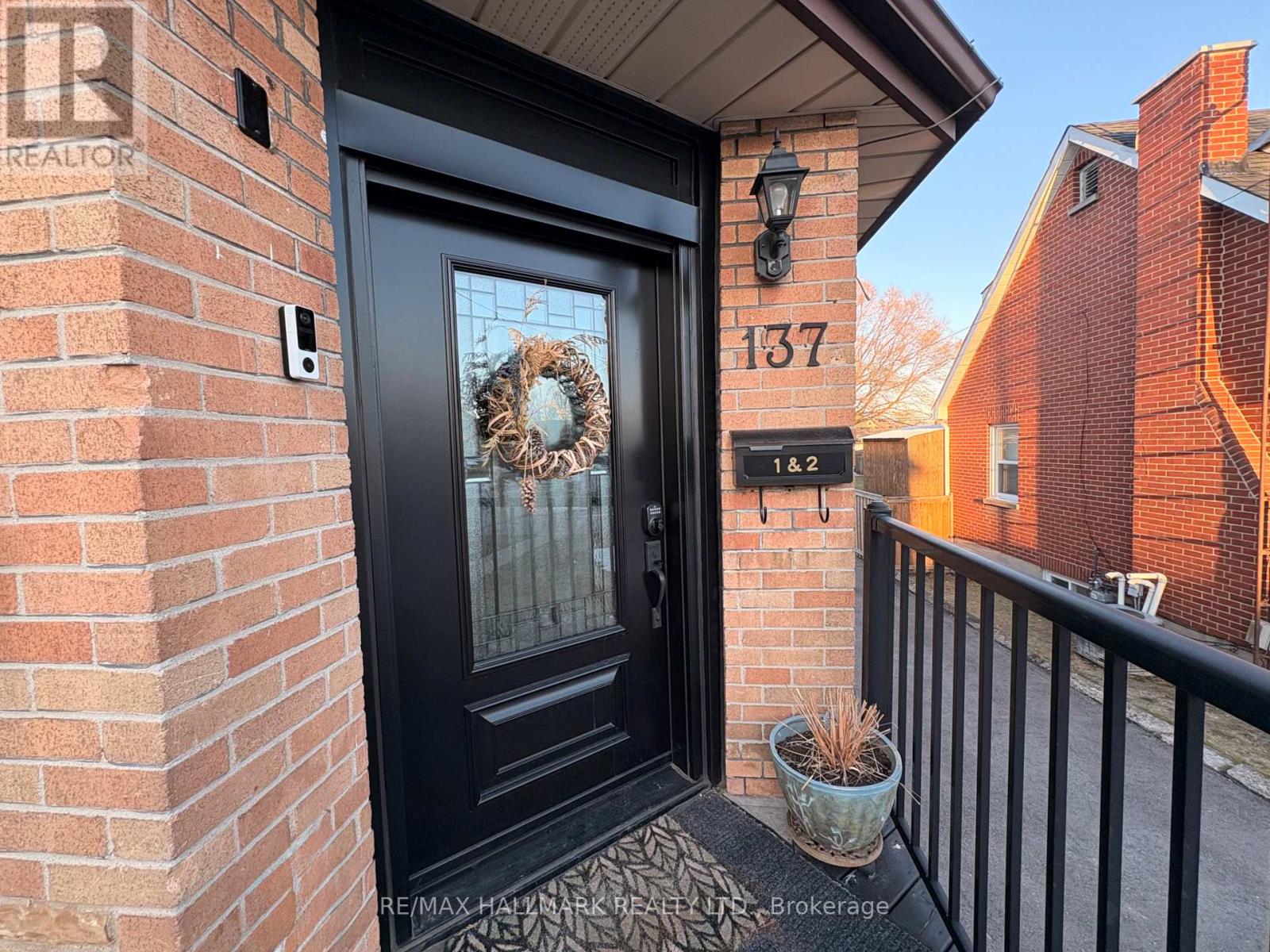 A black door with a wreath on it and a mailbox with the number 137 on it.