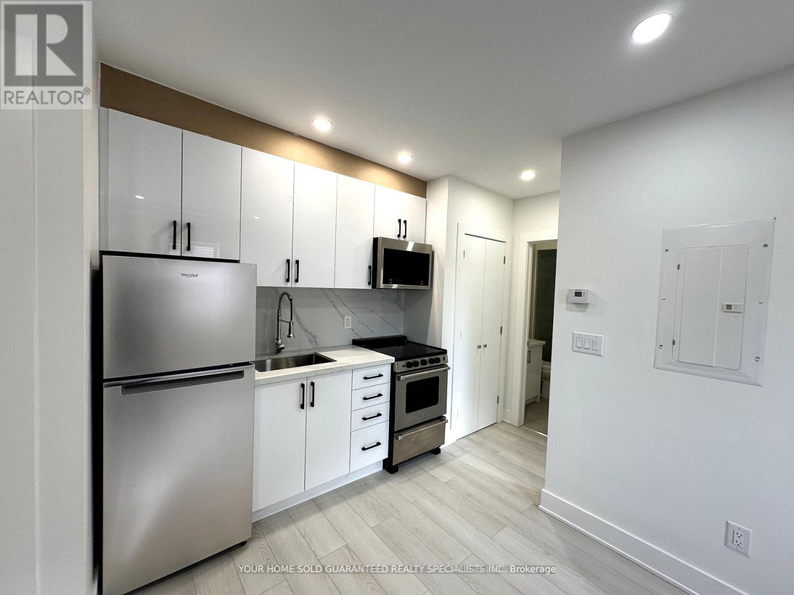 A modern kitchen with stainless steel appliances and white cabinets.