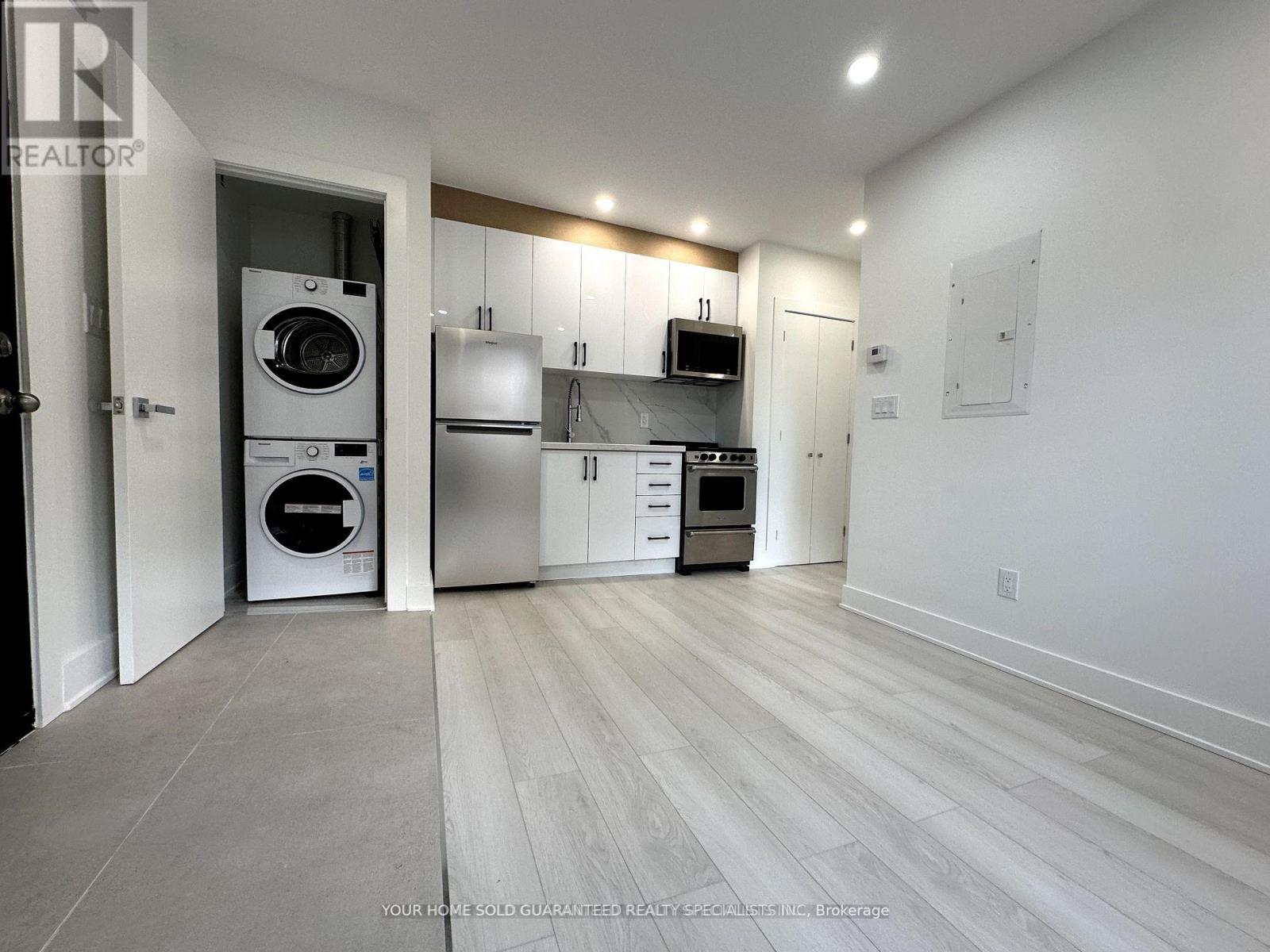 A modern kitchen with white appliances and cabinets.