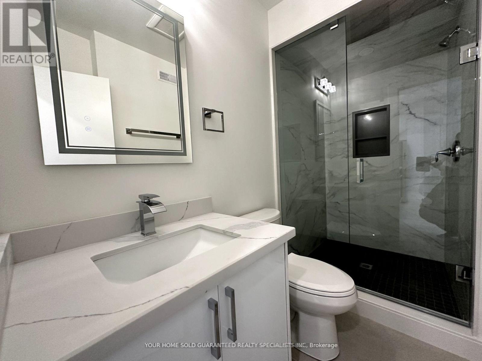 A bathroom with a sink, toilet, and shower.
