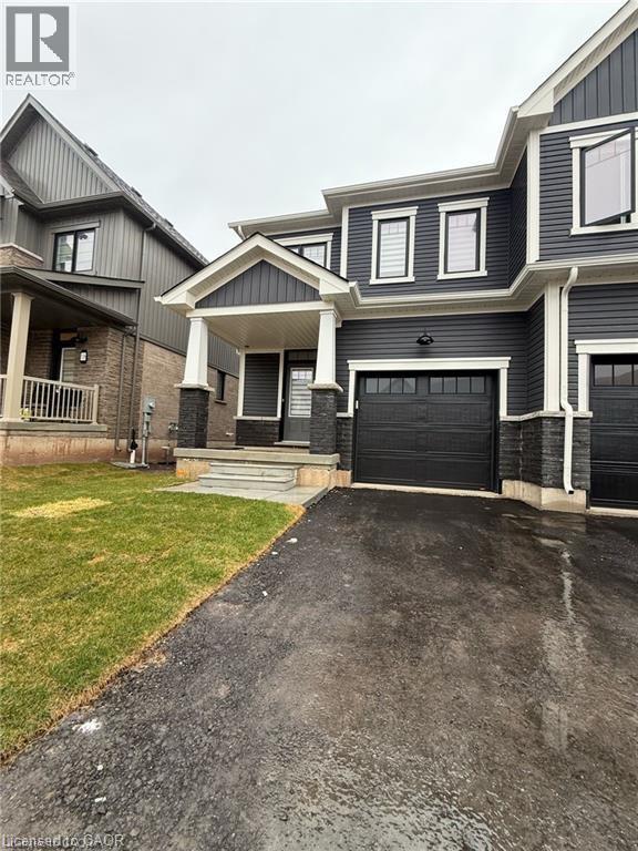 A grey house with a black garage door in front.