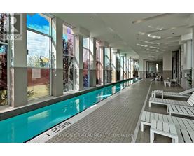 A pool area with a long rectangular pool and benches on the side.