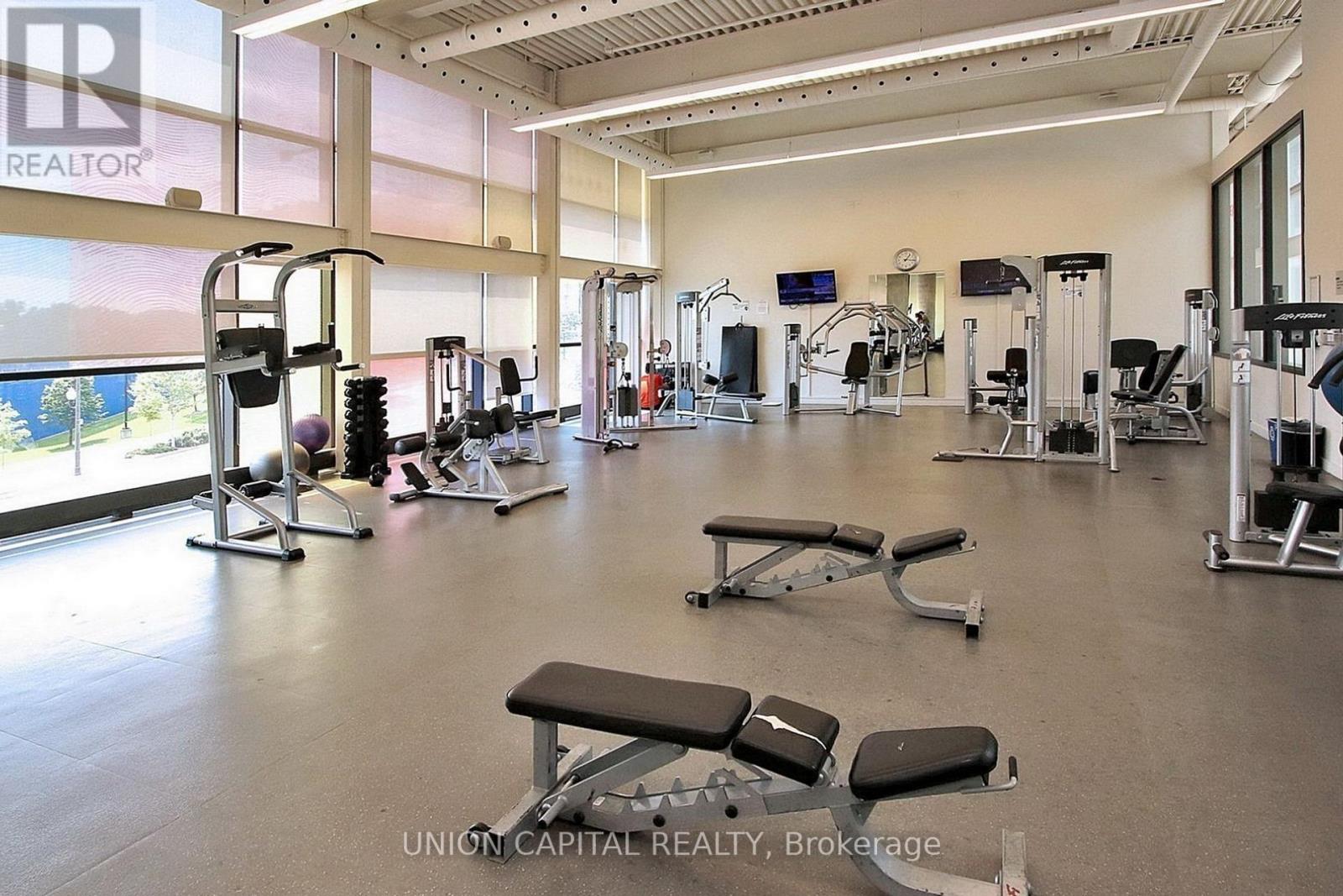 A gym with a variety of equipment including treadmills, weights, and exercise machines.