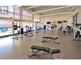 A gym with a variety of equipment including treadmills, weights, and exercise machines.