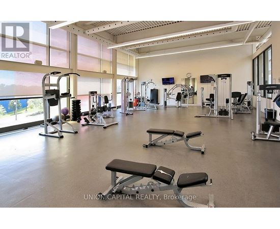 A gym with a variety of equipment including treadmills, weights, and exercise machines.