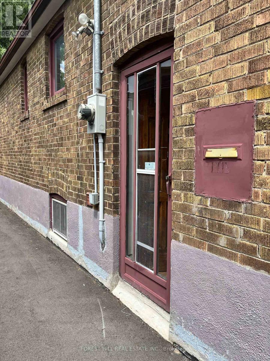 A red door with a mailbox on the side of a brick building.