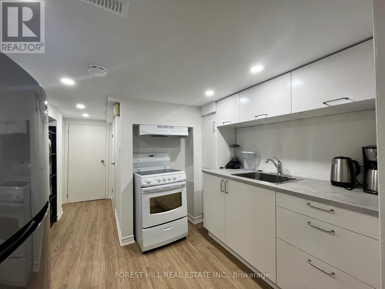 A kitchen with a white oven and cabinets.