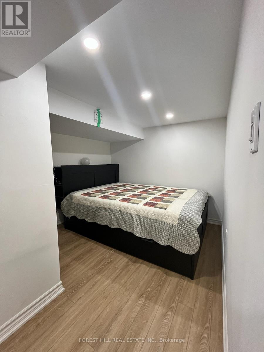 A bedroom with a bed and wooden flooring.