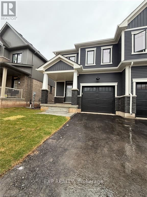 A grey house with a black garage door in front.