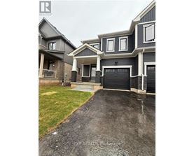 A grey house with a black garage door in front.