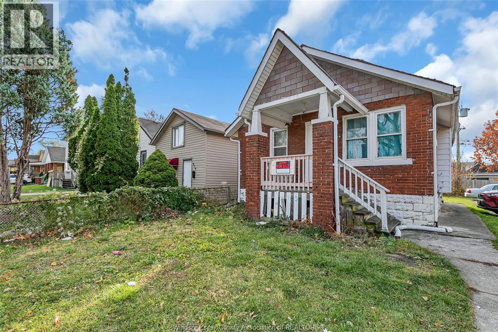 A house with a red brick exterior and a white porch.