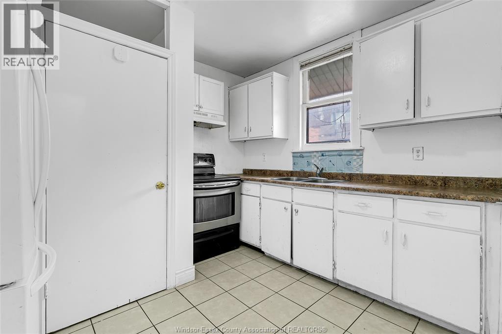 A kitchen with white cabinets and a refrigerator.