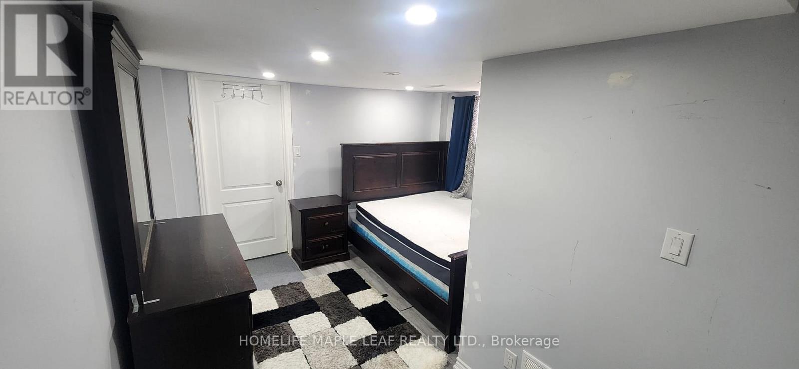 A bedroom with a bed, nightstand, and a dresser.