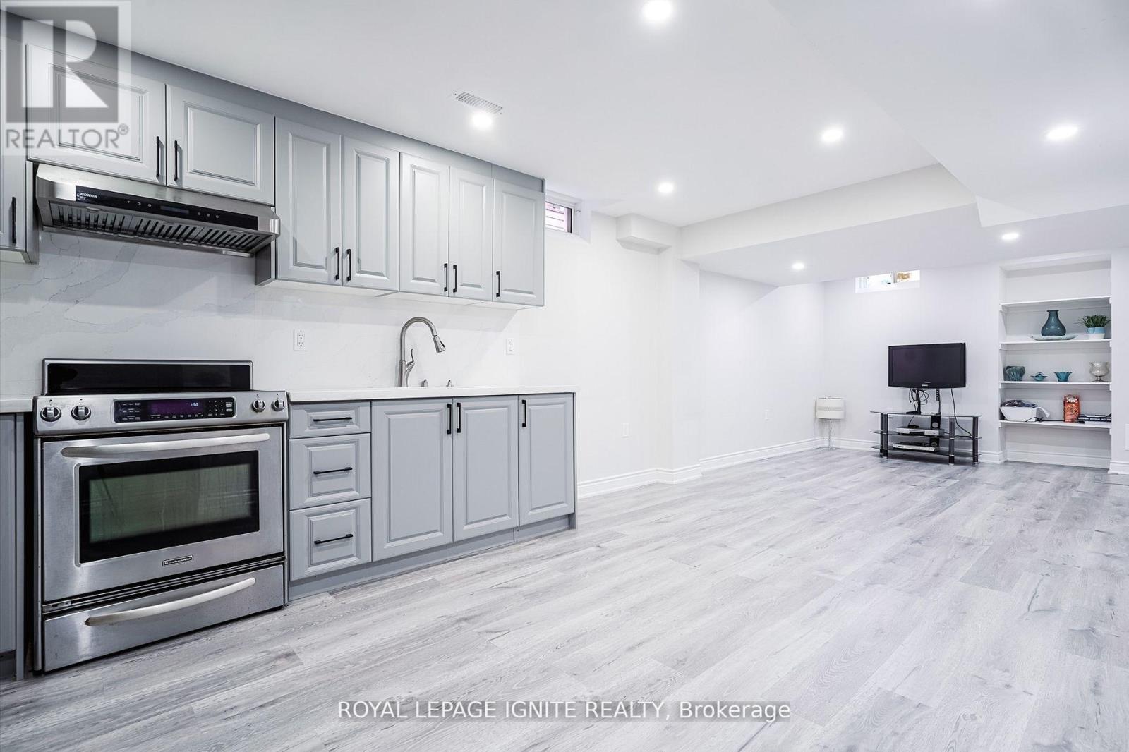 A modern kitchen with a stainless steel oven and grey cabinets.
