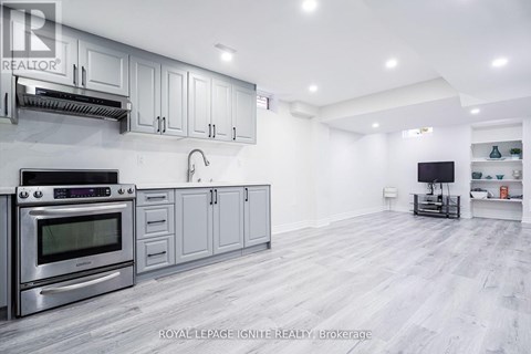 A modern kitchen with a stainless steel oven and grey cabinets.