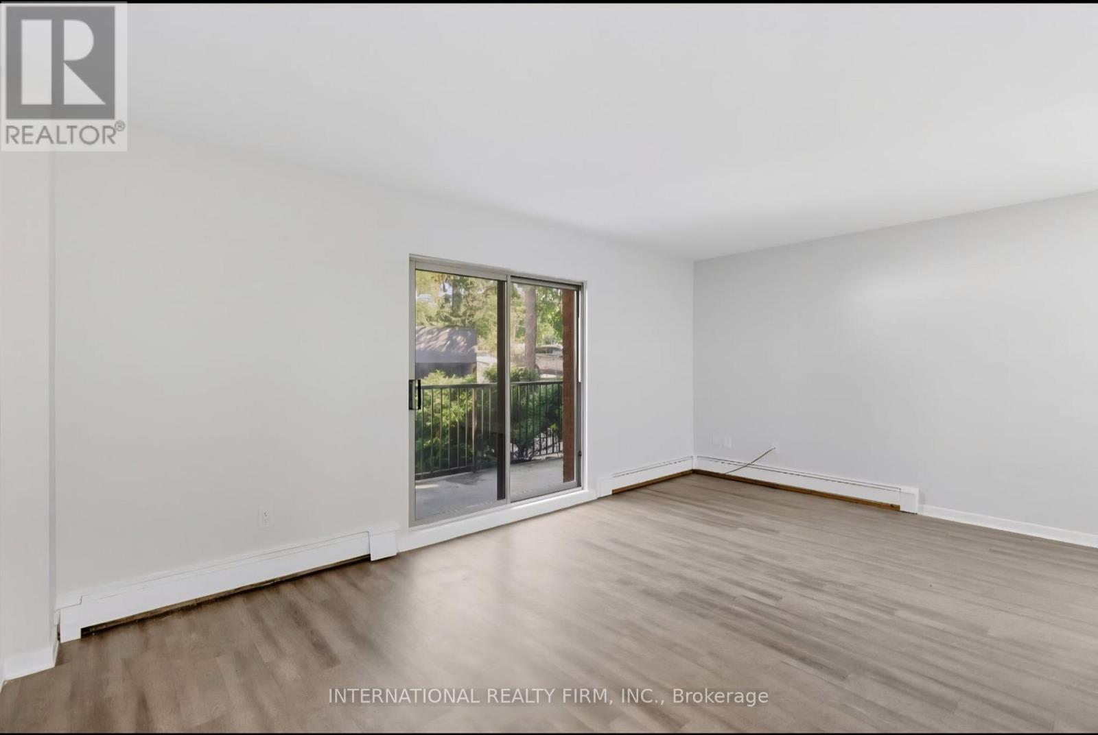 A room with a sliding glass door leading to a balcony.