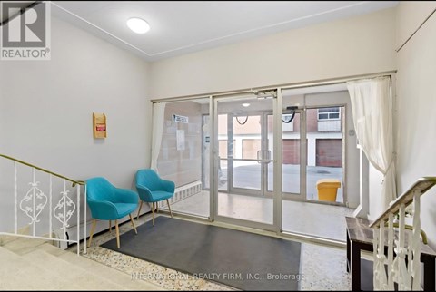 A room with a white wall and a glass door leading to a balcony.