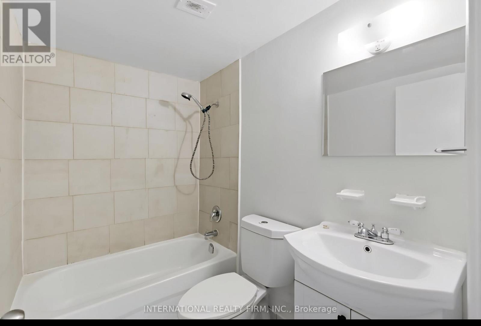 A white bathroom with a tub, toilet, and sink.