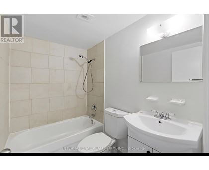 A white bathroom with a tub, toilet, and sink.