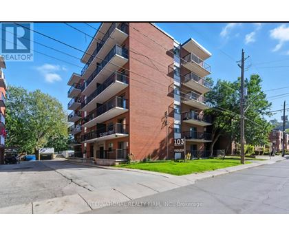 A tall apartment building with the number 103 on it.