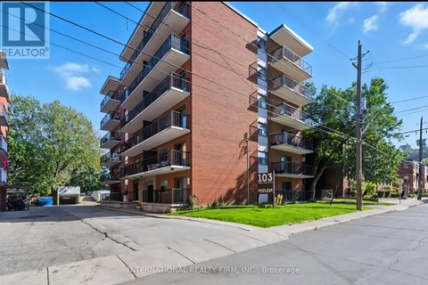 A tall apartment building with the number 103 on it.