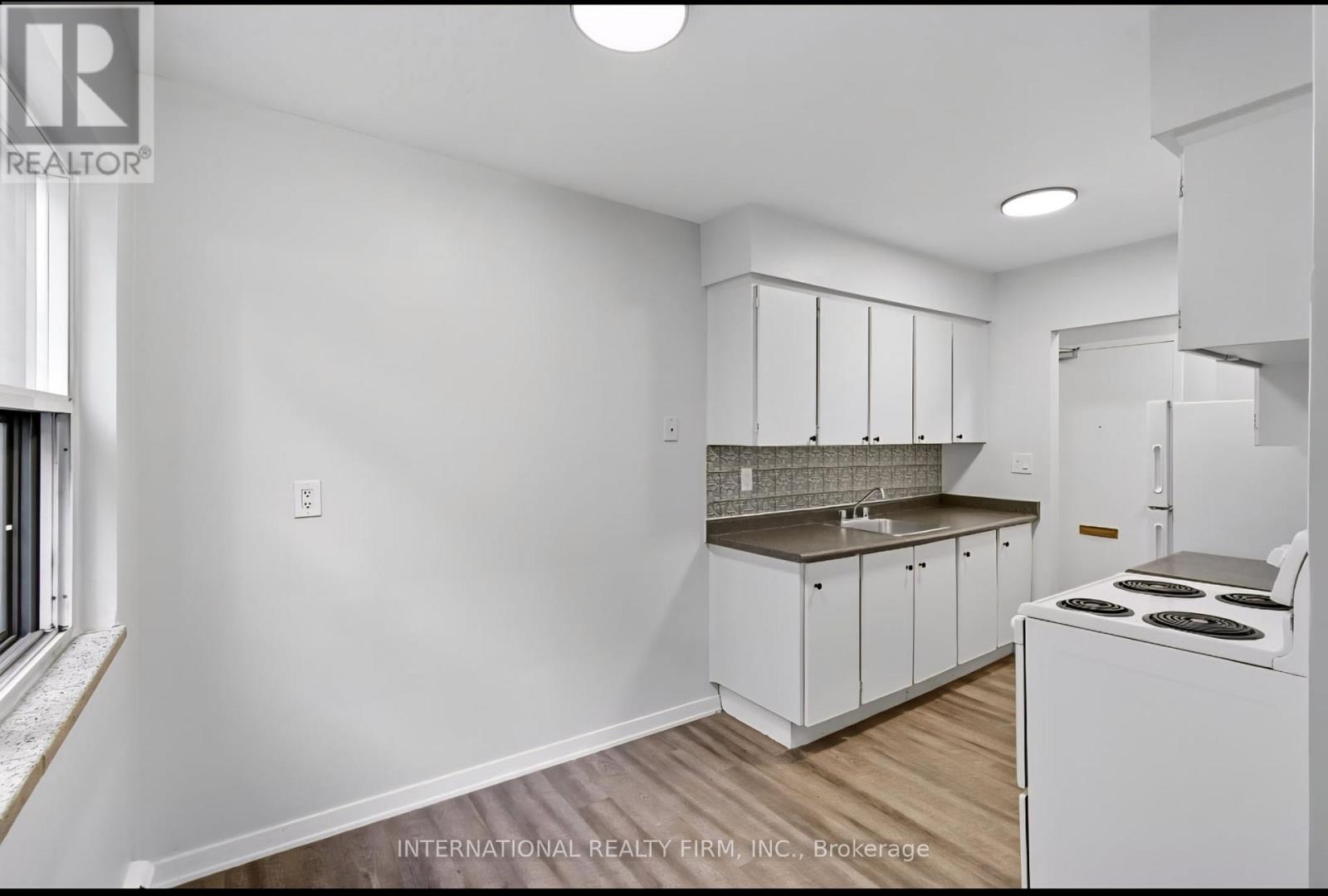 A white kitchen with a stove and cabinets.