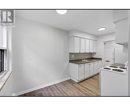 A white kitchen with a stove and cabinets.