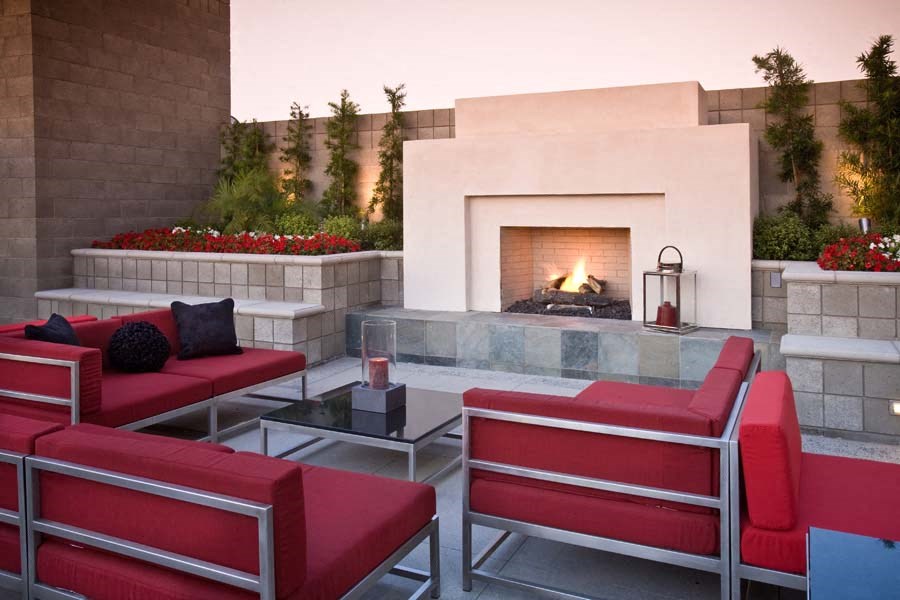 a living room with red chairs and a fireplace