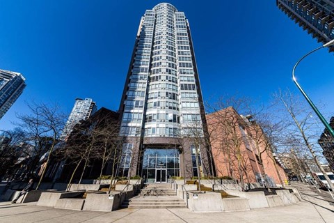 A tall building with many windows is the main focus of this image.