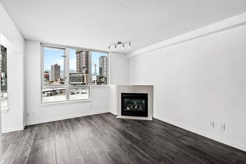 A living room with a fireplace and a view of the city.
