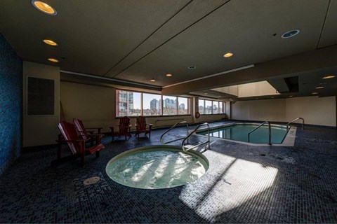 A large indoor swimming pool with a slide and sunlight streaming in through the windows.