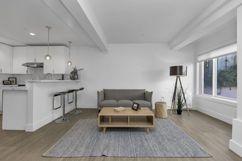 A modern living room with a grey sofa and a wooden coffee table.